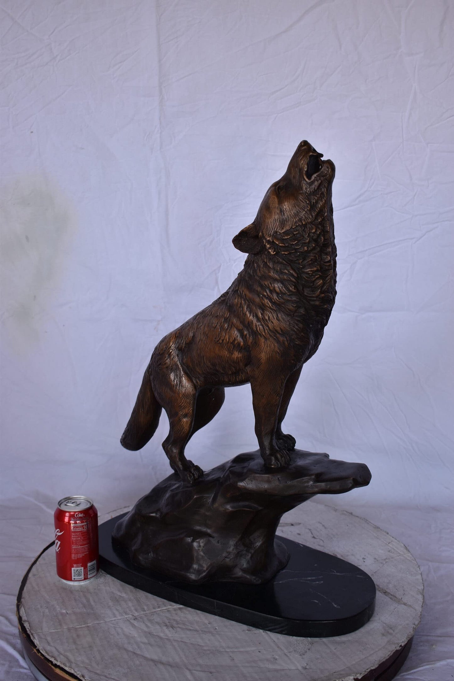 Howling Wolf at Edge of a Cliff Bronze Statue - Size: 9" L x 20" W x 26" H.