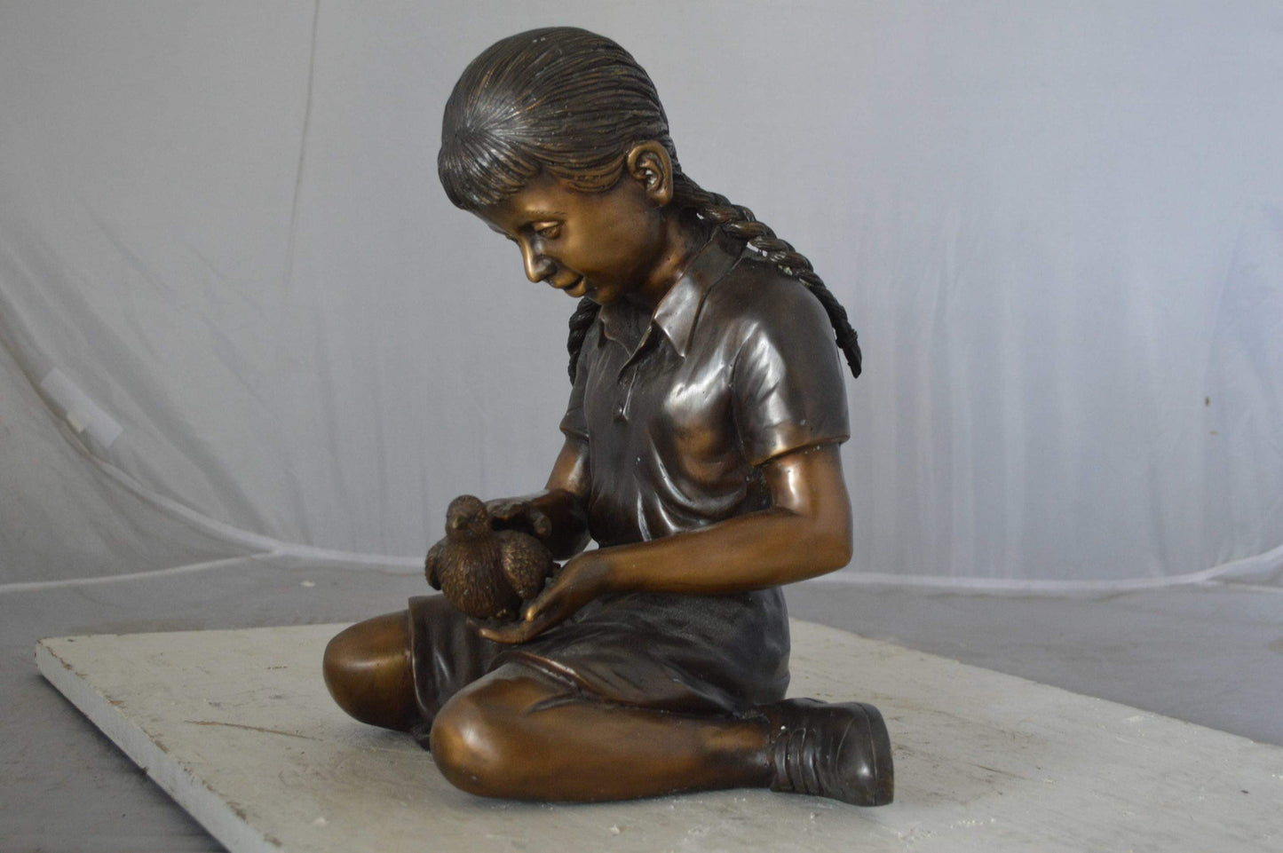 Young seated girl with bird bronze statue - Size: 12"L x 9"W x 14"H.