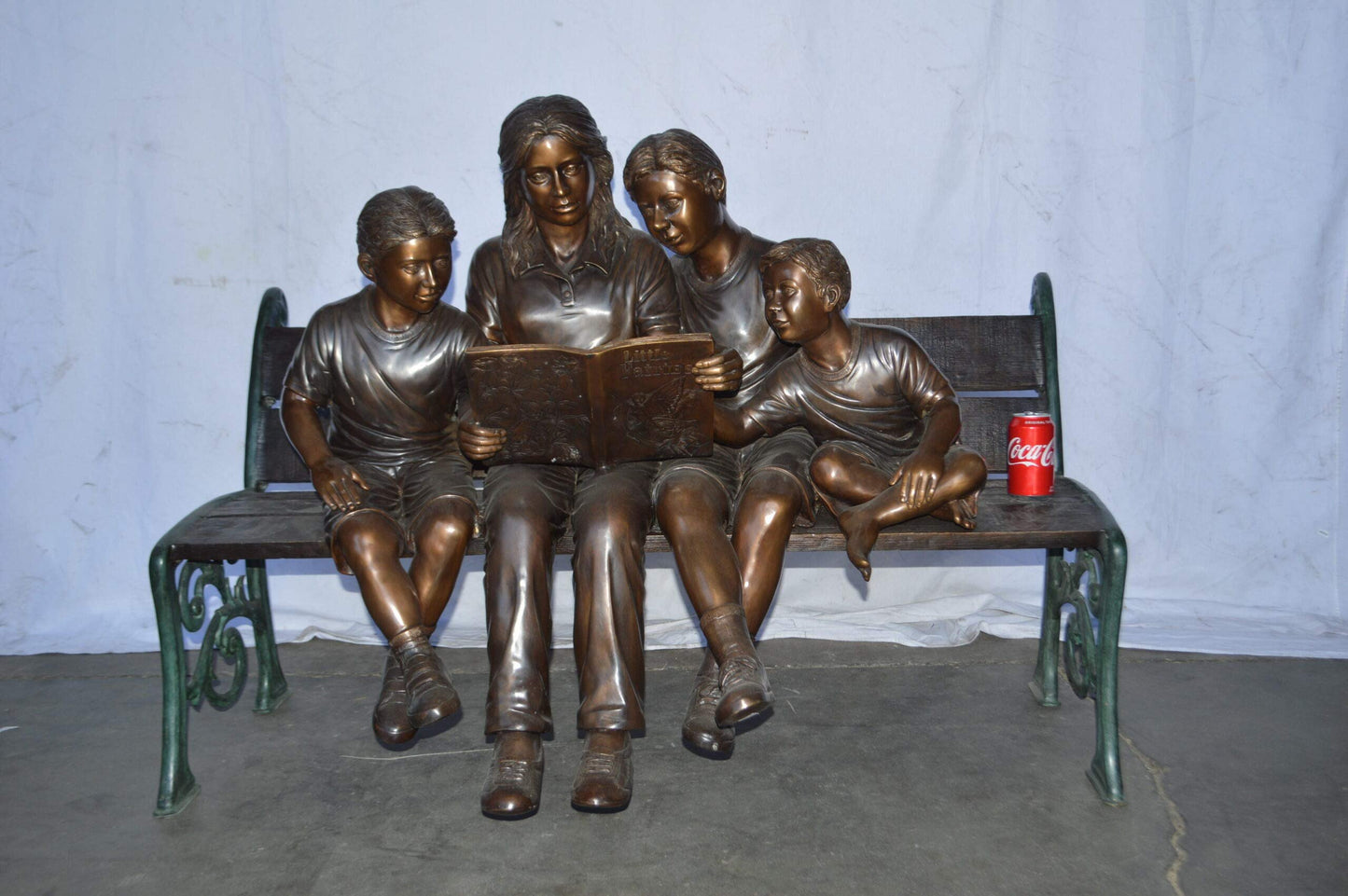 Mom and boys reading stories on bench bronze statue - Size: 53"L x 33"W x 39"H.