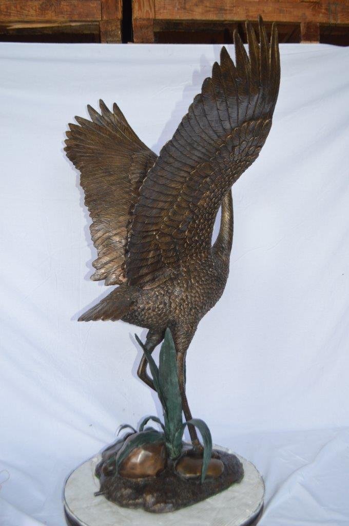 Crane standing on a stone bronze statue -  Size: 28"L x 32"W x 49"H.