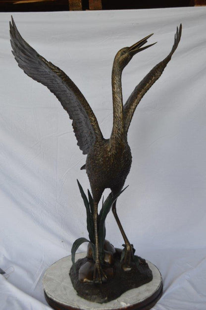 Crane standing on a stone bronze statue -  Size: 28"L x 32"W x 49"H.