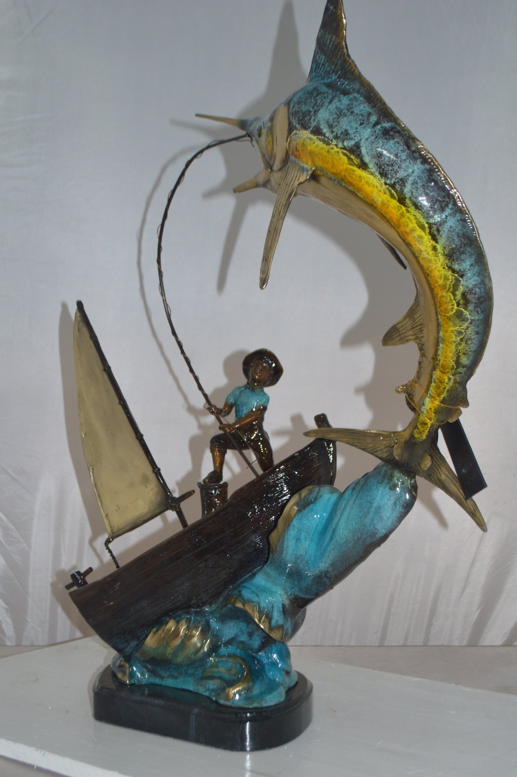 Old Man Fishing a Large Catch Bronze Statue -  Size: 27"L x 13"W x 30"H.