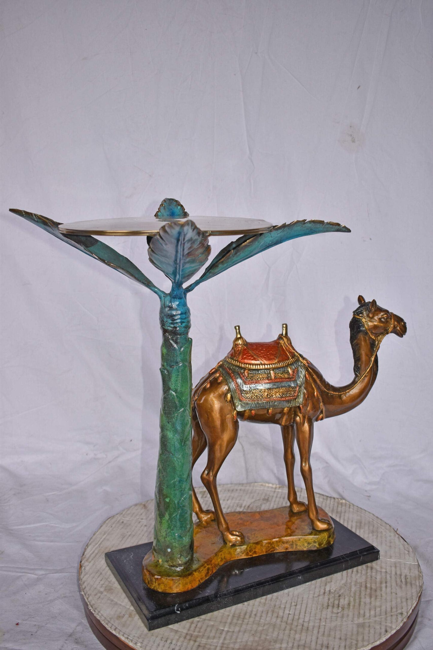 Camel Standing Under A Palm Tree Bronze Statue - Size: 20"L x 29"W x 25"H.