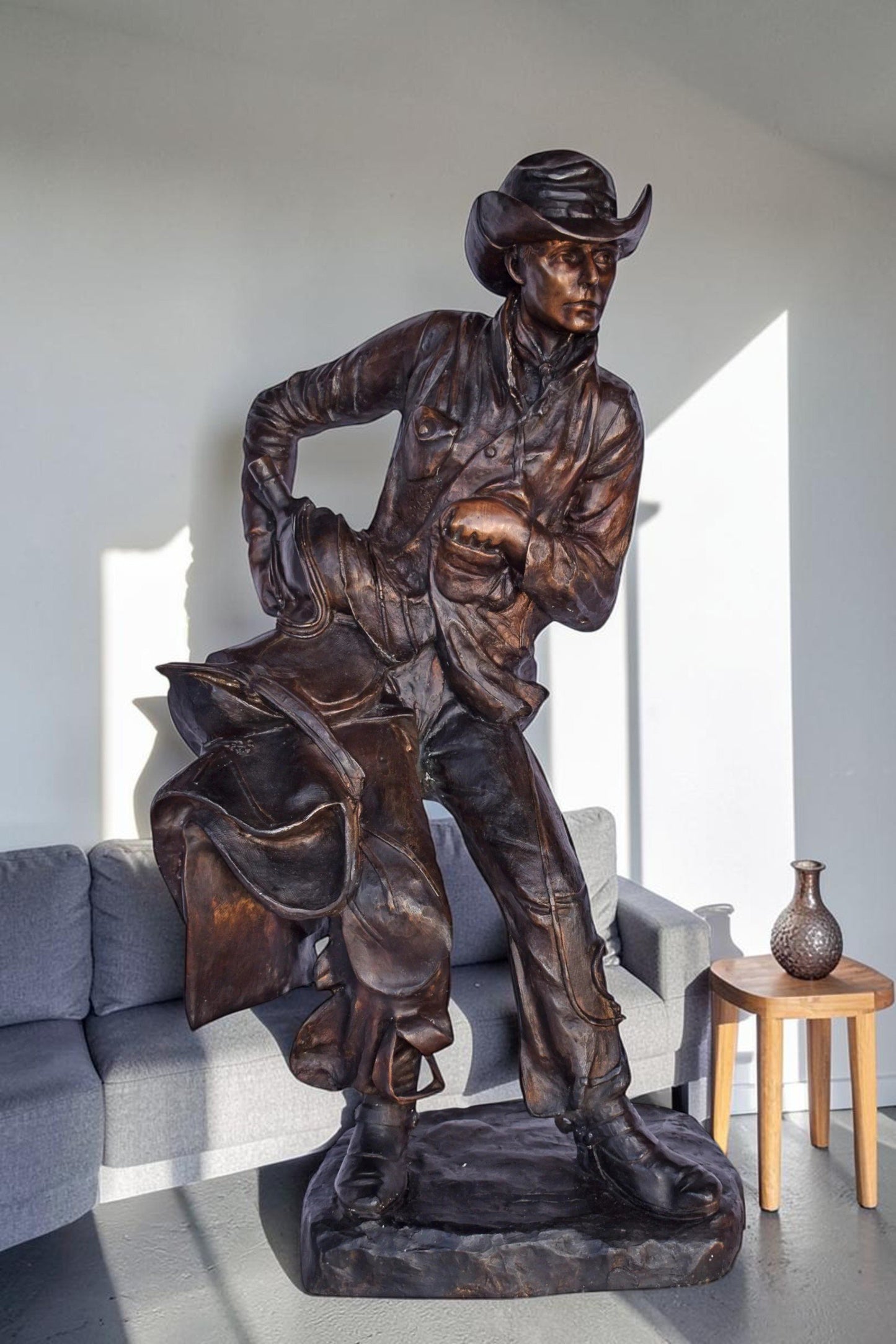 Cowboy Holding His Saddle Bronze Statue - Size: 20"L x 14"W x 35"H.