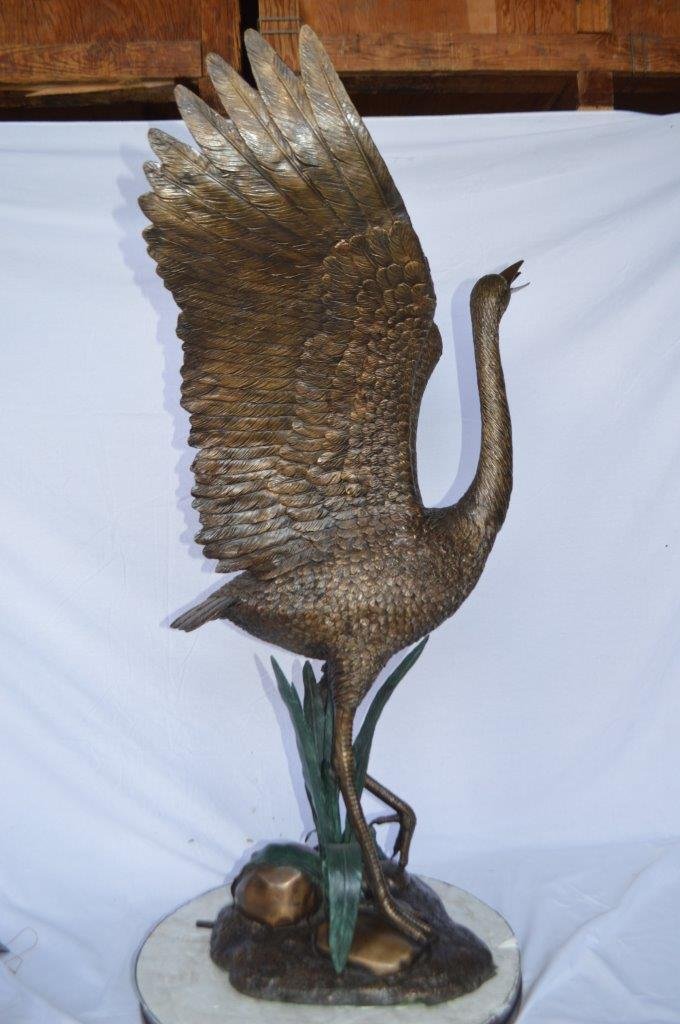 Crane standing on a stone bronze statue -  Size: 28"L x 32"W x 49"H.
