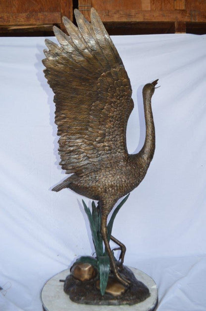 Crane standing on a stone bronze statue -  Size: 28"L x 32"W x 49"H.