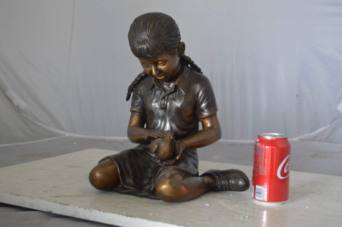 Young seated girl with bird bronze statue - Size: 12"L x 9"W x 14"H.