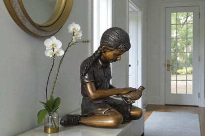 Young seated girl with bird bronze statue - Size: 12"L x 9"W x 14"H.