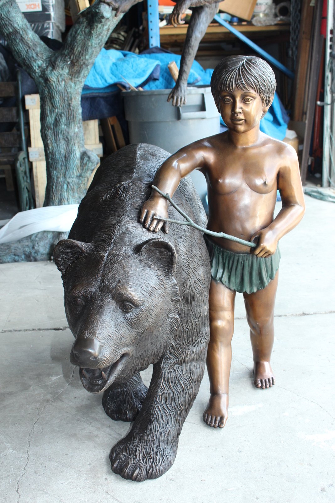 A bear with a boy bronze statue -  Size: 39"L x 24"W x 32"H.
