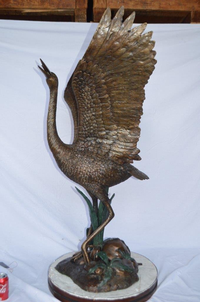 Crane standing on a stone bronze statue -  Size: 28"L x 32"W x 49"H.
