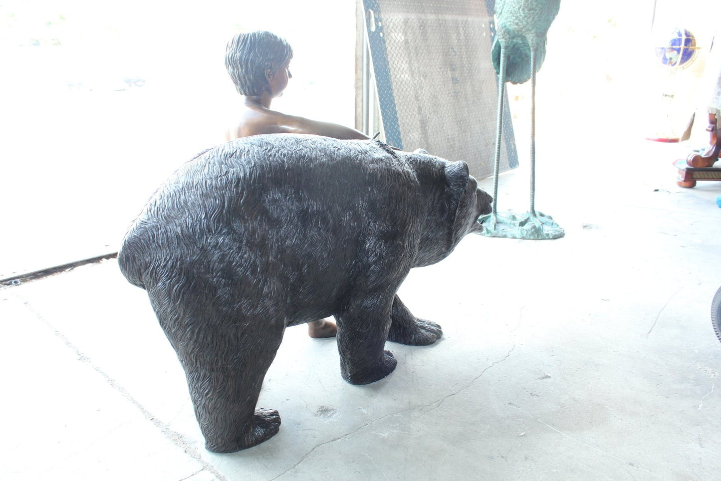A bear with a boy bronze statue -  Size: 39"L x 24"W x 32"H.