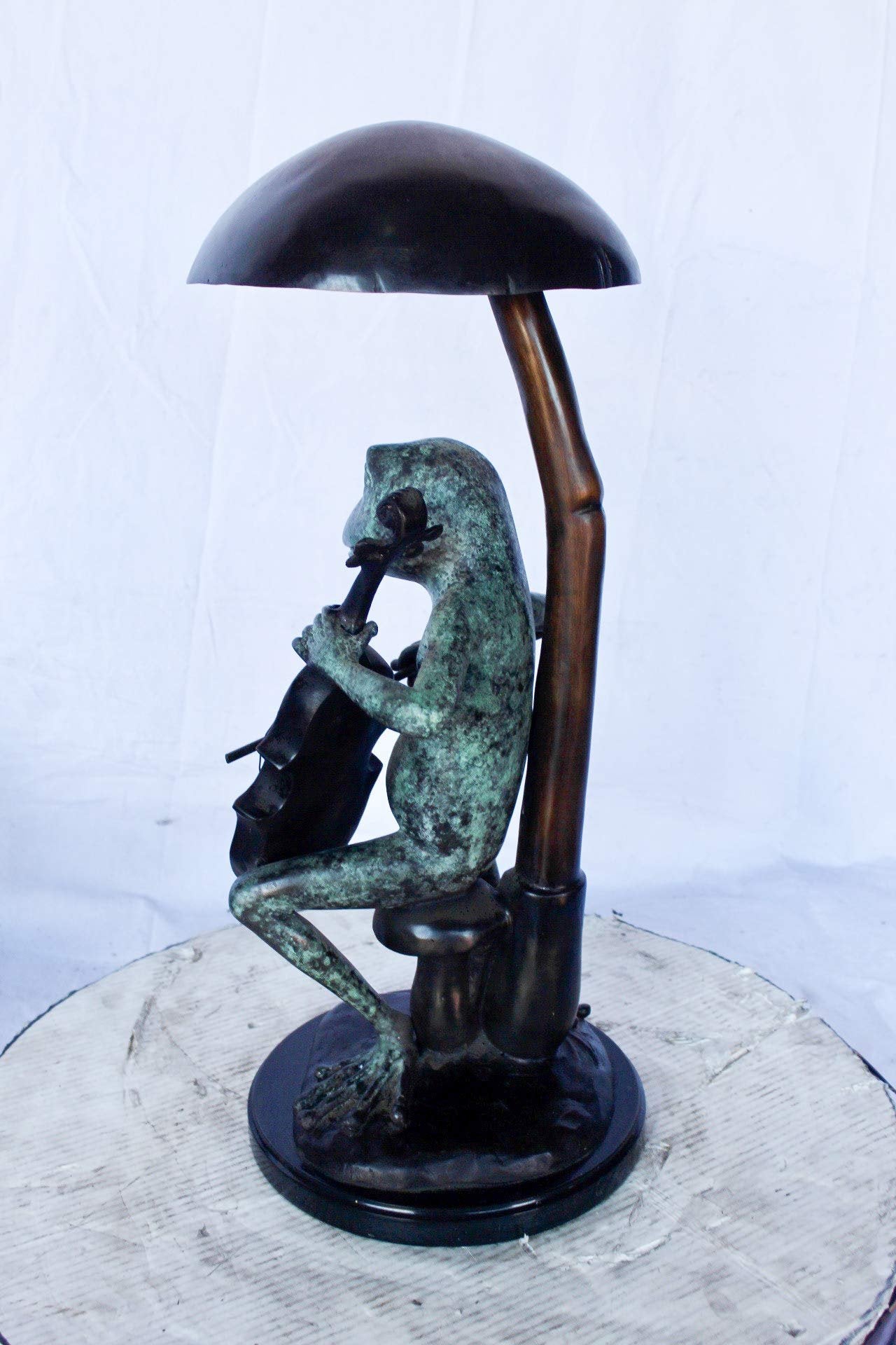 Frog playing cello under mushroom bronze statue -  Size: 10"L x 10"W x 24"H.