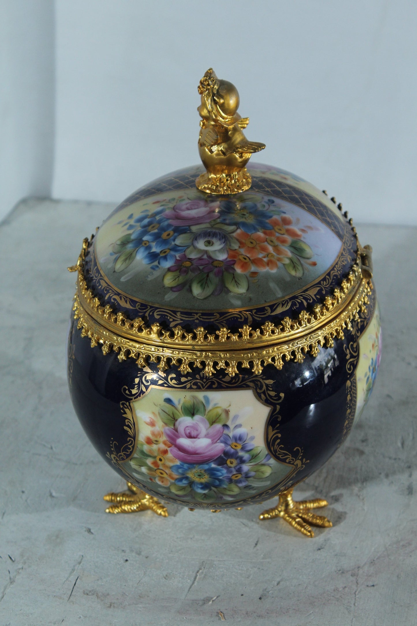 NIFAO Porcelain floral egg shaped lidded box with cherub and chicken feet 11"x8"x12"H