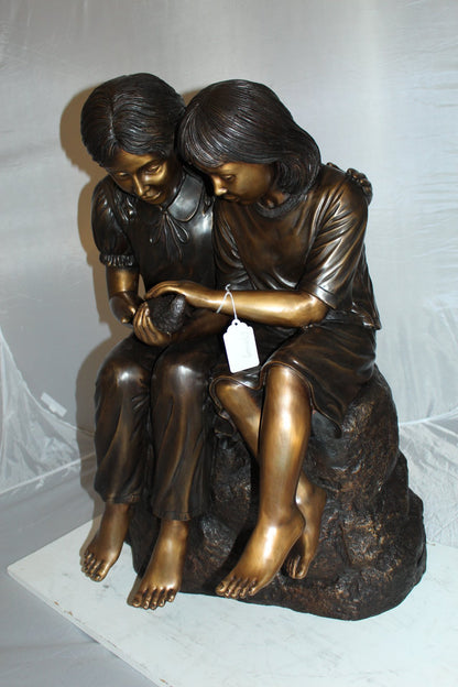 Two kids holding a bird Bronze Statue -  Size: 18"L x 26"W x 34"H.