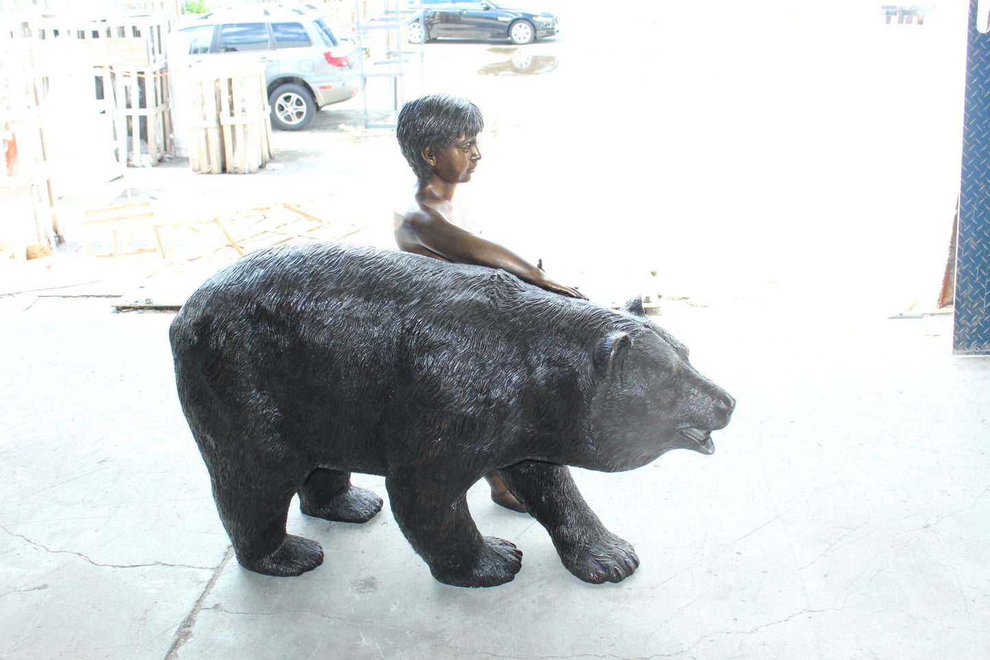 A bear with a boy bronze statue -  Size: 39"L x 24"W x 32"H.