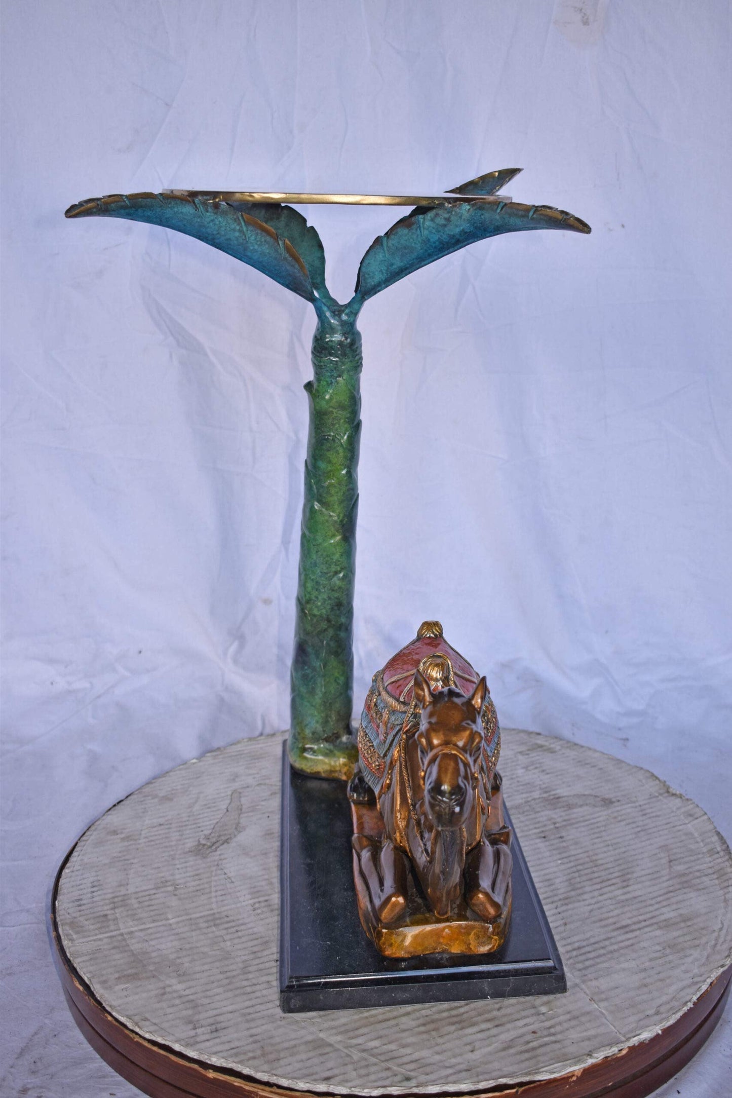 Camel Sitting Under A Palm Tree Bronze Statue - Size: 17"L x 27"W x 23"H.
