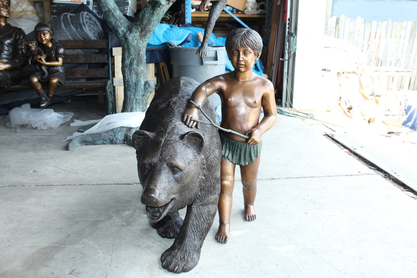 A bear with a boy bronze statue -  Size: 39"L x 24"W x 32"H.