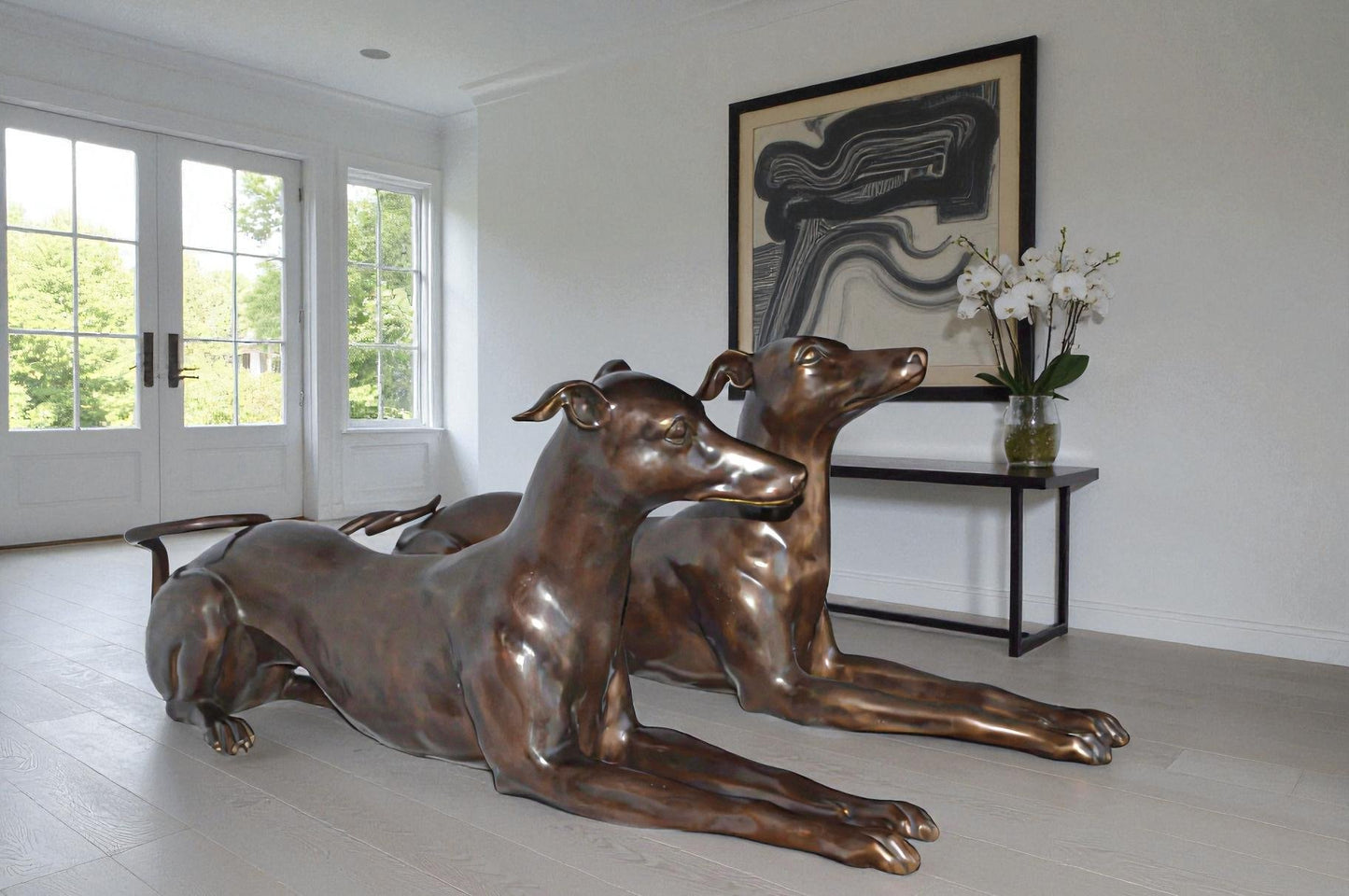 Pair of Greyhound dogs laying down Bronze Statues - Size: 50"L x 11"W x 20"H.
