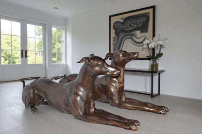 Pair of Greyhound dogs laying down Bronze Statues - Size: 50"L x 11"W x 20"H.