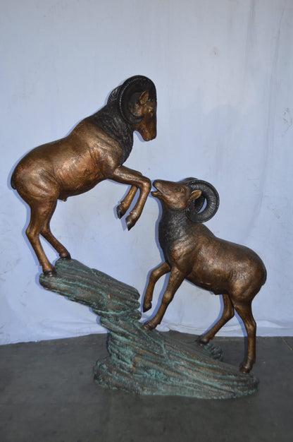 Two Life Size Rams on a rock Bronze Statue - Size: 49"L x 20"W x 64"H.