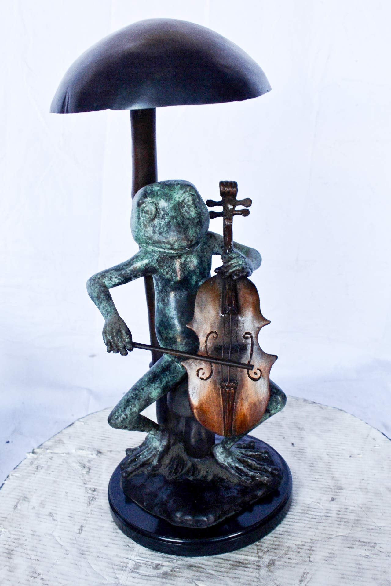 Frog playing cello under mushroom bronze statue -  Size: 10"L x 10"W x 24"H.