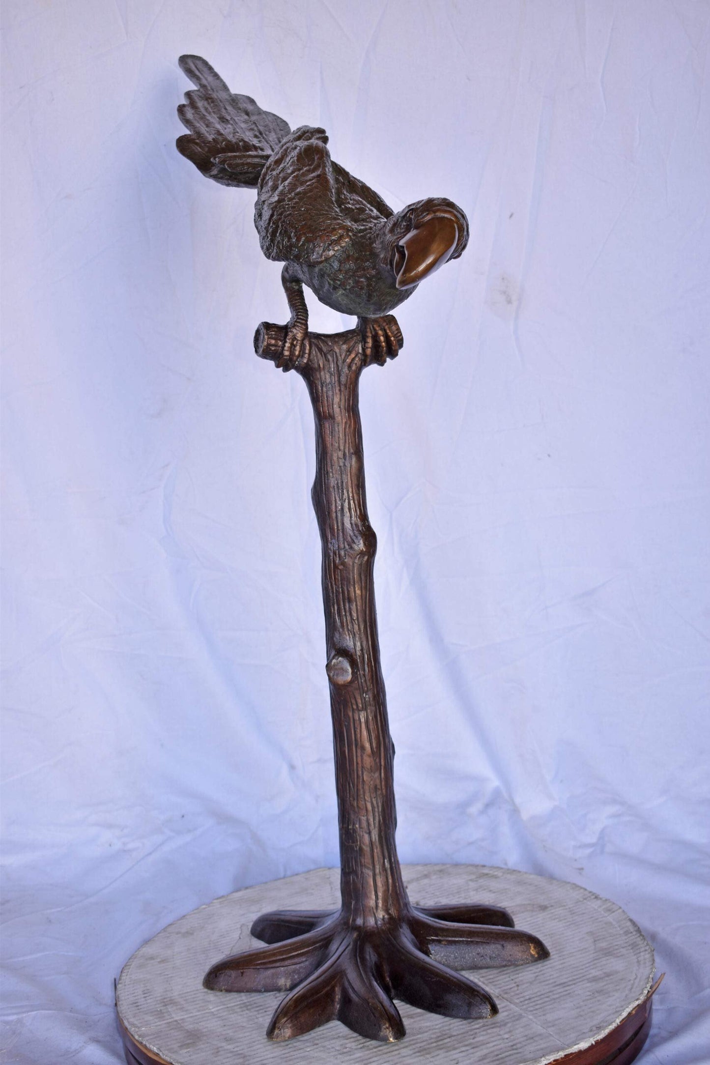 Parrot on a Tree looking Down Bronze Statue - Size: 37"L x 15"W x 47"H.
