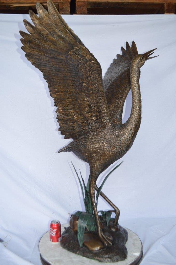 Crane standing on a stone bronze statue -  Size: 28"L x 32"W x 49"H.