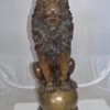 Pair of lions standing on balls, bronze statues -  Size: 14"L x 16"W x 38"H.