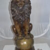 Pair of lions standing on balls, bronze statues -  Size: 14"L x 16"W x 38"H.