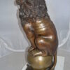 Pair of lions standing on balls, bronze statues -  Size: 14"L x 16"W x 38"H.