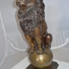 Pair of lions standing on balls, bronze statues -  Size: 14"L x 16"W x 38"H.