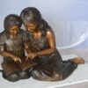 Two Girls Reading a Book Bronze Statue -  Size: 33"L x 21"W x 23"H.