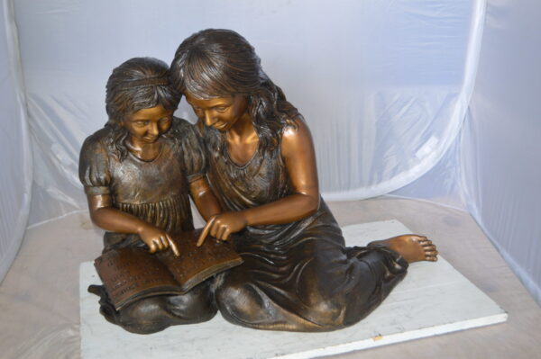 Two Girls Reading a Book Bronze Statue -  Size: 33"L x 21"W x 23"H.