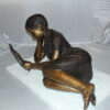 Girl laying reading a book Bronze Statue -  Size: 36"L x 17"W x 18"H.