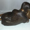 Girl laying reading a book Bronze Statue -  Size: 36"L x 17"W x 18"H.