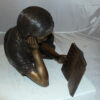 Girl laying reading a book Bronze Statue -  Size: 36"L x 17"W x 18"H.