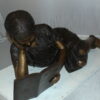 Girl laying reading a book Bronze Statue -  Size: 36"L x 17"W x 18"H.