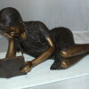 Girl laying reading a book Bronze Statue -  Size: 36"L x 17"W x 18"H.