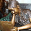 Girl laying on a bench reading a book Bronze Statue -  Size: 27"L x 39"W x 32"H