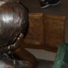 Girl laying on a bench reading a book Bronze Statue -  Size: 27"L x 39"W x 32"H