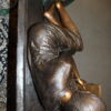 Girl laying on a bench reading a book Bronze Statue -  Size: 27"L x 39"W x 32"H