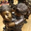 Boy Giving Girl Piggyback Ride Bronze Statue -  Size: 23"L x 16"W x 46"H.