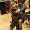 Boy Giving Girl Piggyback Ride Bronze Statue -  Size: 23"L x 16"W x 46"H.