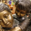 Boy Giving Girl Piggyback Ride Bronze Statue -  Size: 23"L x 16"W x 46"H.