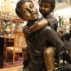 Boy Giving Girl Piggyback Ride Bronze Statue -  Size: 23"L x 16"W x 46"H.